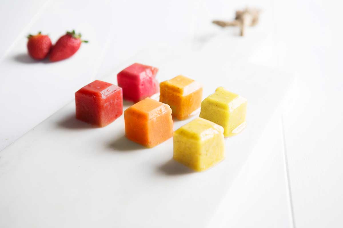 Image of 6 cubes of frozen Fruit Puree sitting on a white benchtop