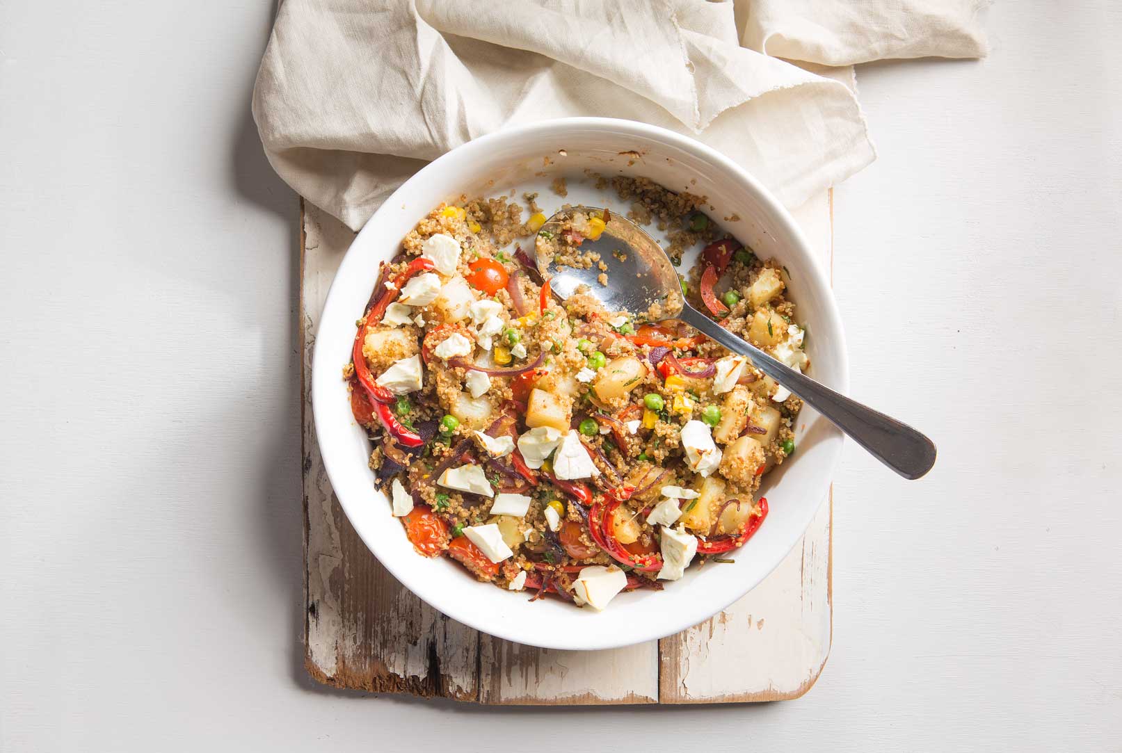 Roast Vegie and Quinoa Bake in a white bowl with spoon