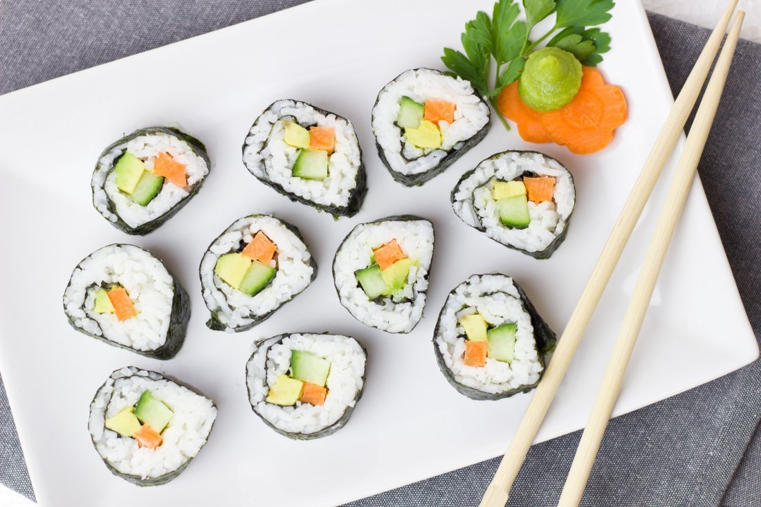 vegetable sushi on white plate with a pair of chopsticks
