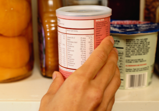 picture of a hand grasping a can of food displaying food label